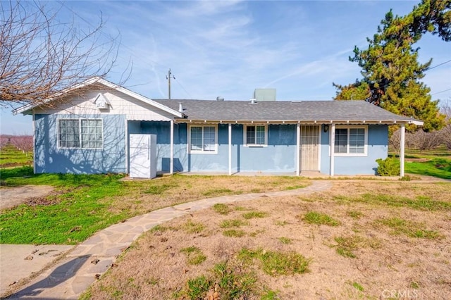 ranch-style home with a front lawn and stucco siding