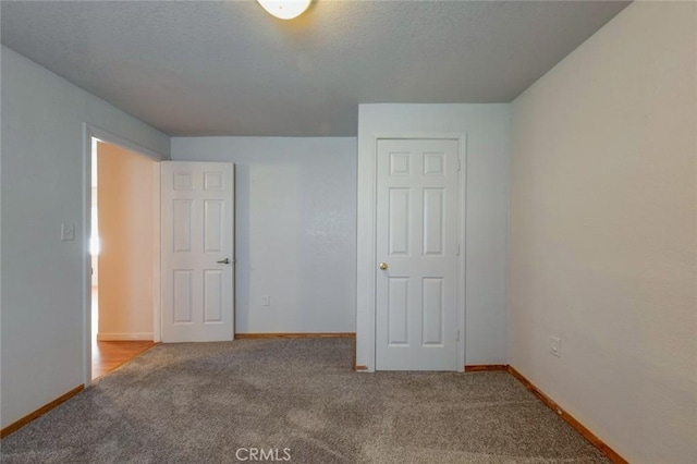 unfurnished bedroom featuring carpet floors and baseboards