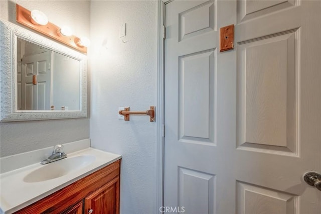 bathroom featuring a textured wall and vanity