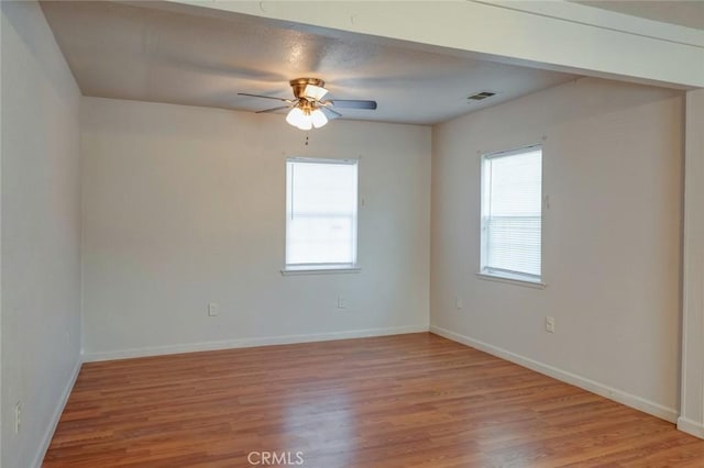 unfurnished room featuring baseboards, ceiling fan, a wealth of natural light, and light wood-type flooring
