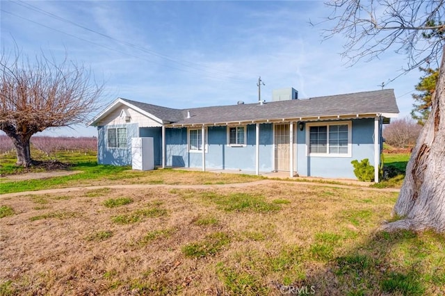 ranch-style house featuring stucco siding and a front lawn