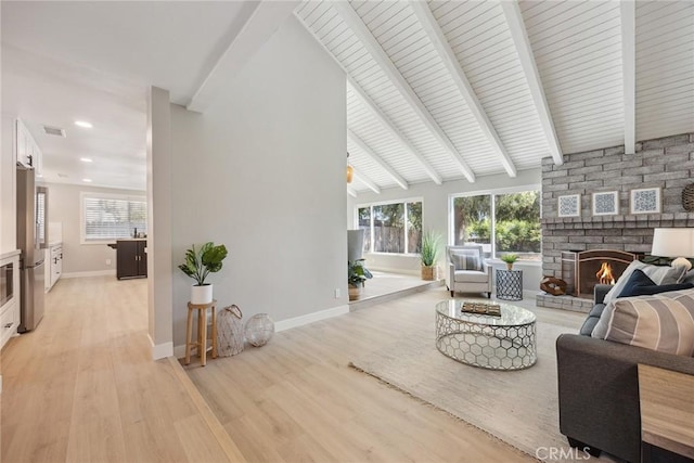 18128 Cari Ln, Yorba Linda, CA 92886 - living area featuring visible vents, baseboards, light wood-type flooring, a large fireplace, and lofted ceiling with beams