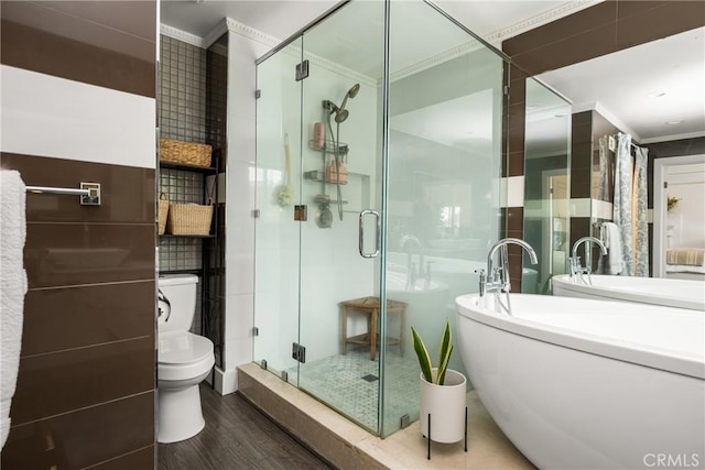 full bathroom featuring a shower stall, ornamental molding, and wood finished floors