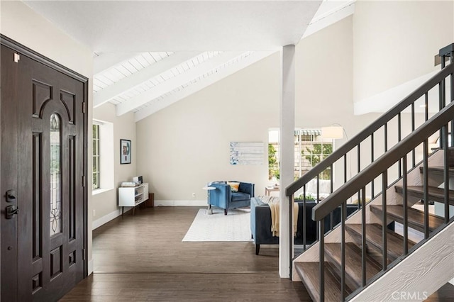 foyer entrance with stairway, dark wood finished floors, high vaulted ceiling, and plenty of natural light