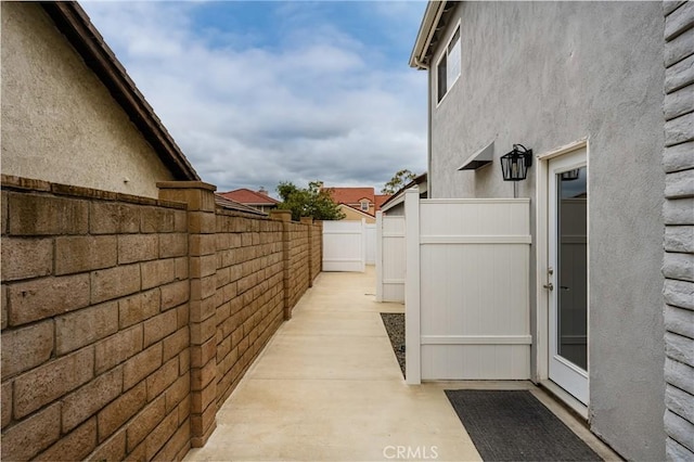 view of home's exterior with stucco siding and fence