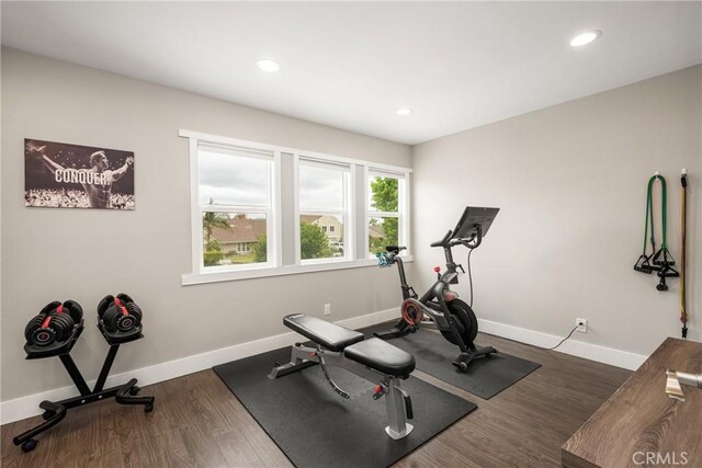 workout area featuring dark wood finished floors, baseboards, and recessed lighting