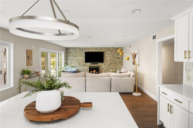 dining area with visible vents, recessed lighting, dark wood-style flooring, baseboards, and a stone fireplace
