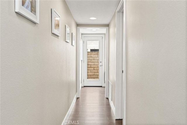 hall with visible vents, wood finished floors, baseboards, and recessed lighting