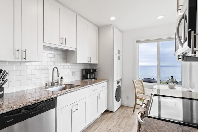 kitchen featuring backsplash, stainless steel appliances, white cabinets, and a sink