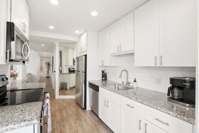 kitchen featuring a sink, white cabinetry, appliances with stainless steel finishes, and decorative backsplash
