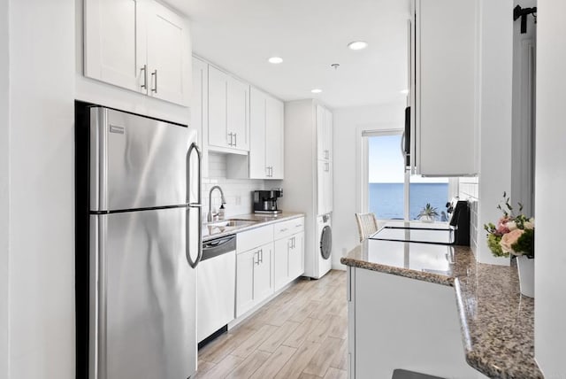 kitchen featuring a sink, appliances with stainless steel finishes, white cabinets, and tasteful backsplash