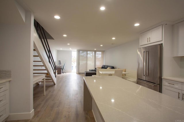 kitchen featuring high end refrigerator, white cabinets, and recessed lighting