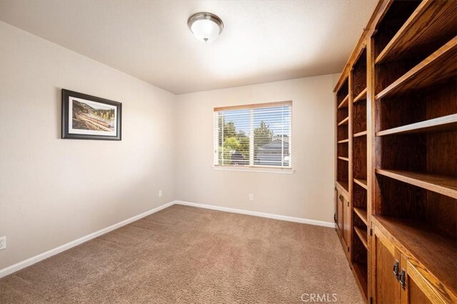 empty room featuring baseboards and carpet