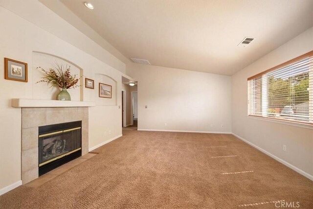 unfurnished living room with baseboards, carpet, visible vents, and a fireplace