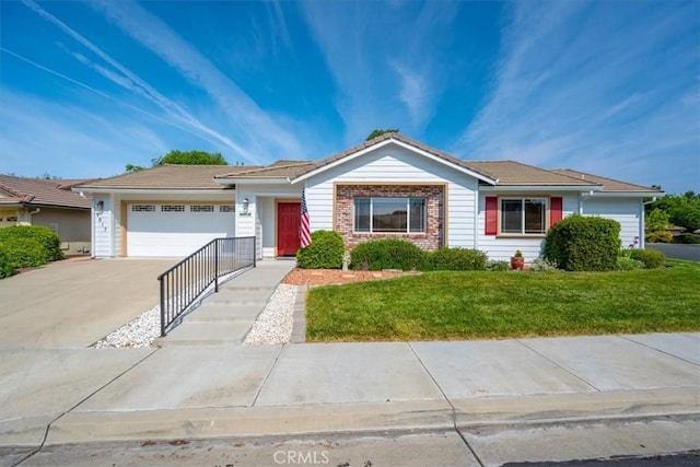 ranch-style house featuring a garage, concrete driveway, a front lawn, and brick siding