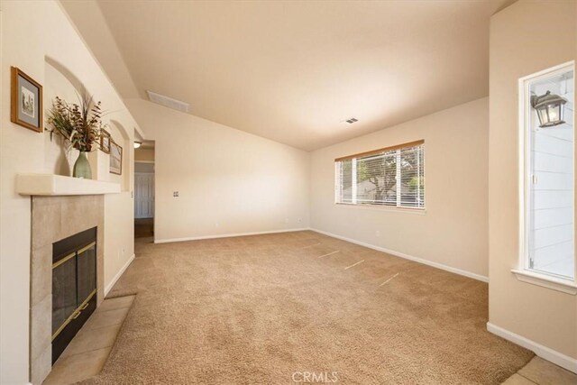 unfurnished living room with carpet floors, baseboards, plenty of natural light, and a fireplace