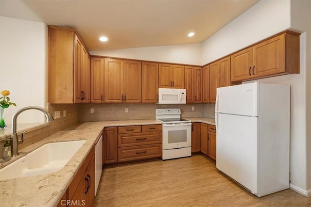 kitchen featuring decorative backsplash, brown cabinets, a sink, light stone counters, and white appliances