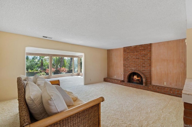 carpeted living area featuring a fireplace, a textured ceiling, and visible vents