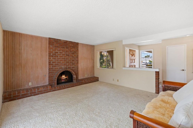 carpeted living room with a textured ceiling and a brick fireplace