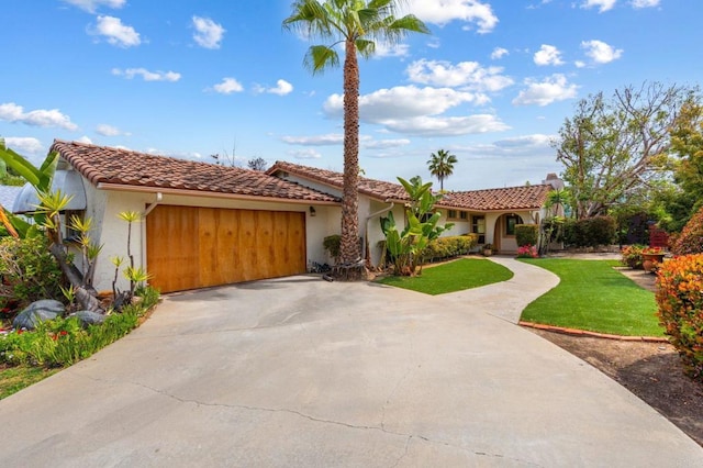 mediterranean / spanish-style home with driveway, a tile roof, a front lawn, an attached garage, and stucco siding