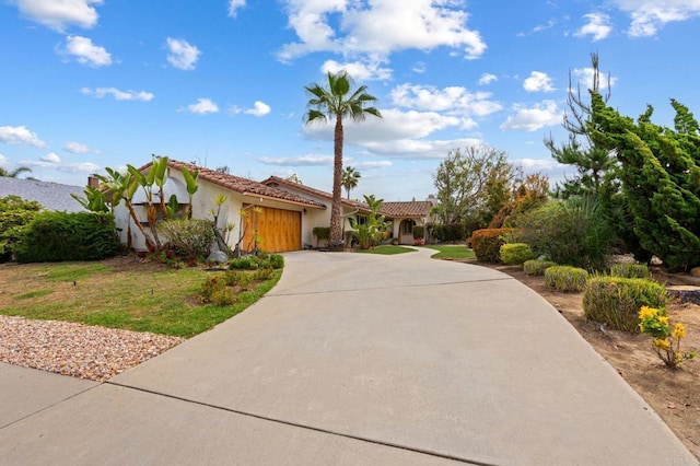 view of front facade with an attached garage, stucco siding, driveway, and a tile roof