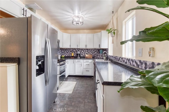12022 W Redbank St, Sun Valley, CA 91352 - kitchen featuring dark countertops, appliances with stainless steel finishes, a sink, backsplash, and white cabinets