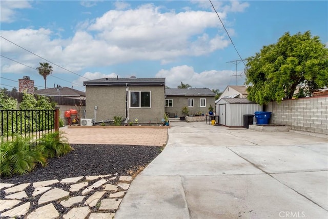 12022 W Redbank St, Sun Valley, CA 91352 - rear view of property with a storage unit, an outbuilding, a patio area, and stucco siding