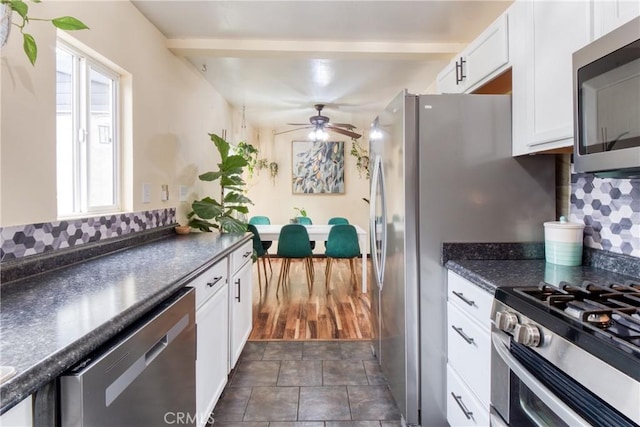 12022 W Redbank St, Sun Valley, CA 91352 - kitchen with appliances with stainless steel finishes, dark countertops, white cabinets, and decorative backsplash