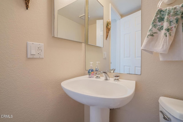 1130 Mandalay Beach Rd, Oxnard, CA 93035 - bathroom featuring toilet, a textured wall, and a sink