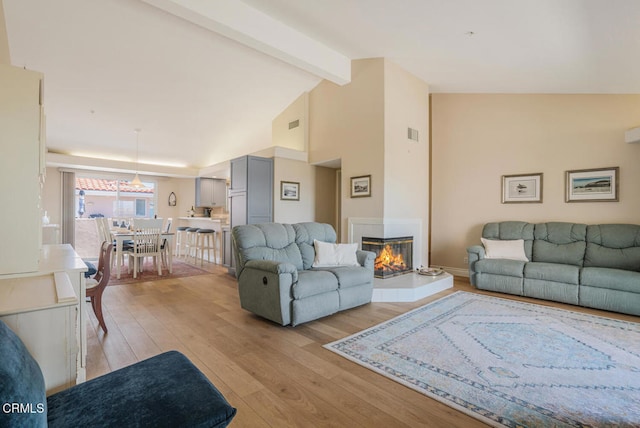 1130 Mandalay Beach Rd, Oxnard, CA 93035 - living room with light wood-style flooring, a multi sided fireplace, baseboards, beamed ceiling, and visible vents