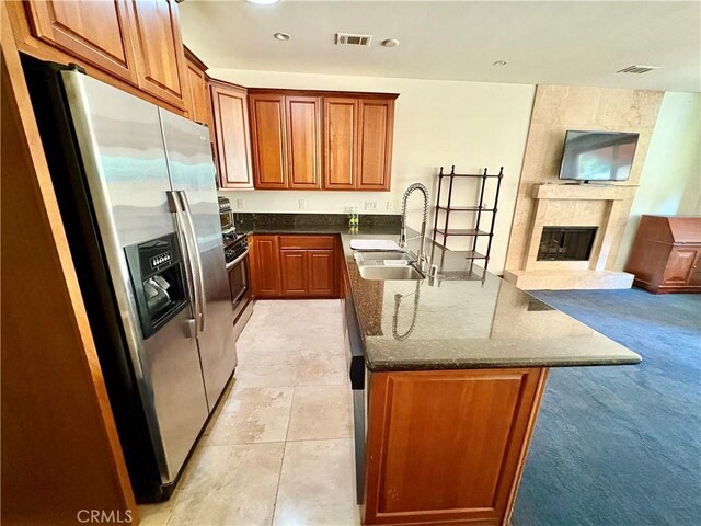 344 Triana Ln Unit 102, Avalon, CA 90704 - kitchen featuring stainless steel refrigerator with ice dispenser, a sink, open floor plan, dark stone counters, and a premium fireplace