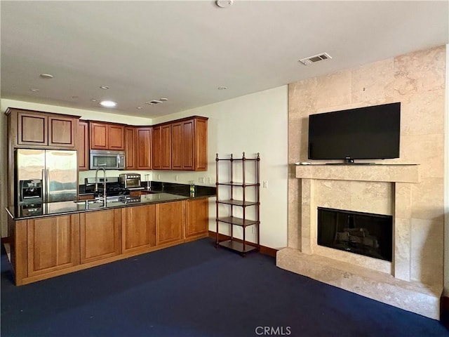 344 Triana Ln Unit 102, Avalon, CA 90704 - kitchen featuring appliances with stainless steel finishes, dark countertops, a peninsula, a sink, and brown cabinets