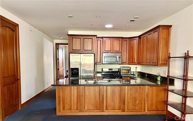 344 Triana Ln Unit 102, Avalon, CA 90704 - kitchen featuring appliances with stainless steel finishes, a peninsula, dark stone countertops, baseboards, and recessed lighting