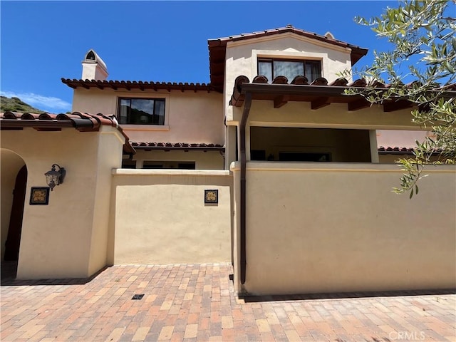 344 Triana Ln Unit 102, Avalon, CA 90704 - view of front of property with a chimney, stucco siding, and a tiled roof