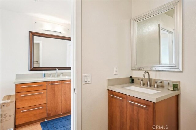 bathroom featuring a sink and two vanities