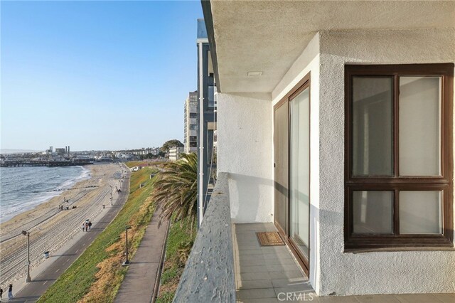 balcony featuring a water view and a view of the beach