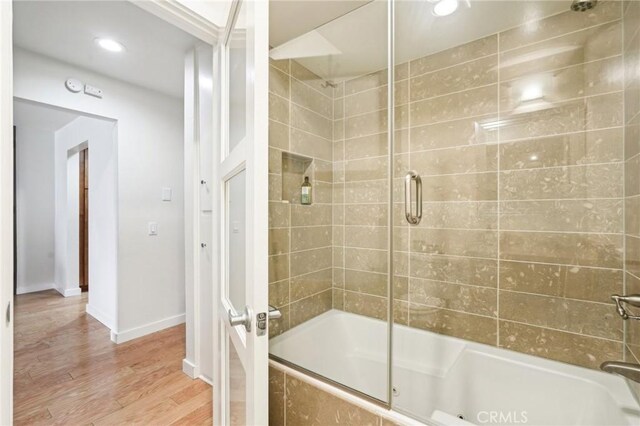 full bathroom featuring wood finished floors, recessed lighting, baseboards, and tiled shower / bath