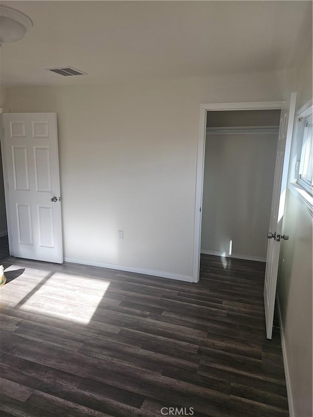 44645 Fig Ave, Lancaster, CA 93534 - unfurnished bedroom featuring baseboards, dark wood-style floors, a closet, and visible vents