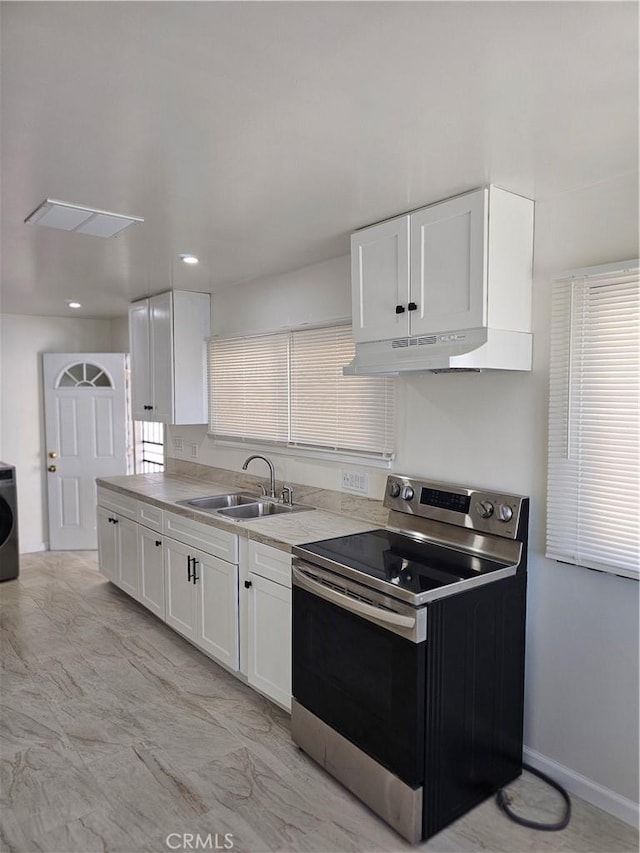44645 Fig Ave, Lancaster, CA 93534 - kitchen featuring white cabinets, stainless steel electric range, a sink, light countertops, and washer / clothes dryer