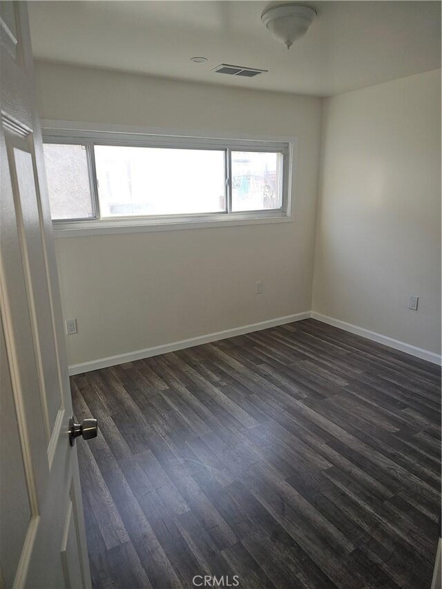 44645 Fig Ave, Lancaster, CA 93534 - unfurnished room featuring visible vents, dark wood-style flooring, and baseboards