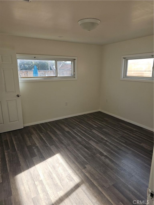 44645 Fig Ave, Lancaster, CA 93534 - unfurnished room featuring baseboards, dark wood-style floors, and a wealth of natural light