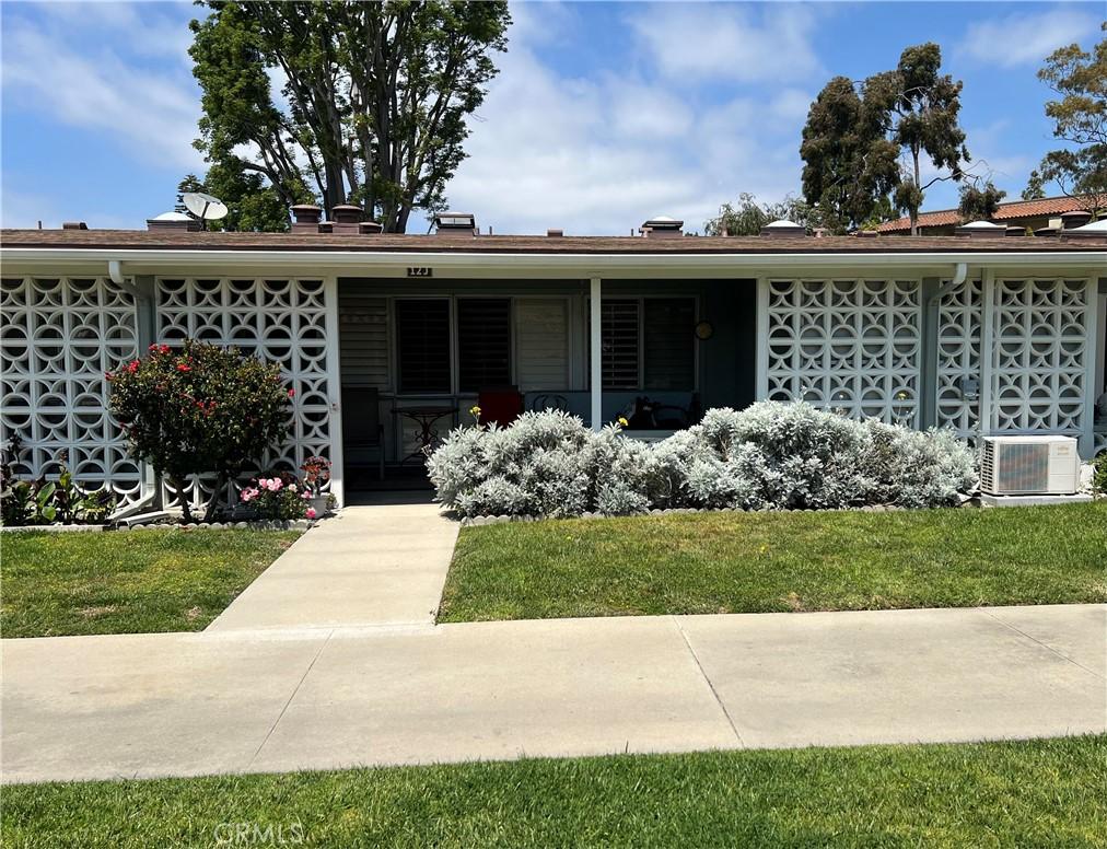 view of front of property with central air condition unit and a front lawn