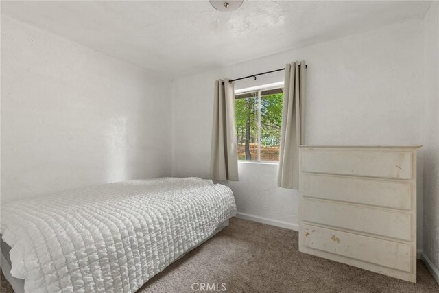 bedroom featuring carpet floors and baseboards