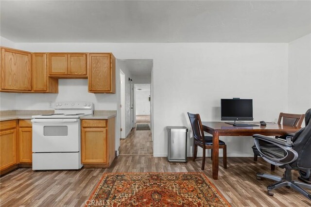 kitchen with light countertops, white range with electric stovetop, and wood finished floors