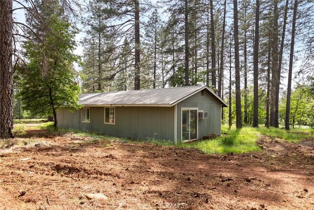 view of home's exterior featuring metal roof and a wall mounted air conditioner