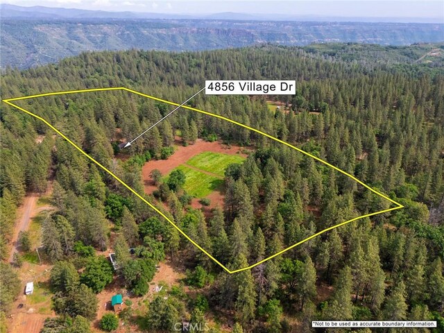 drone / aerial view featuring a mountain view and a wooded view