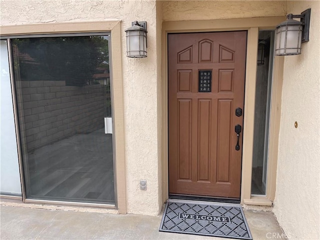 view of exterior entry with stucco siding