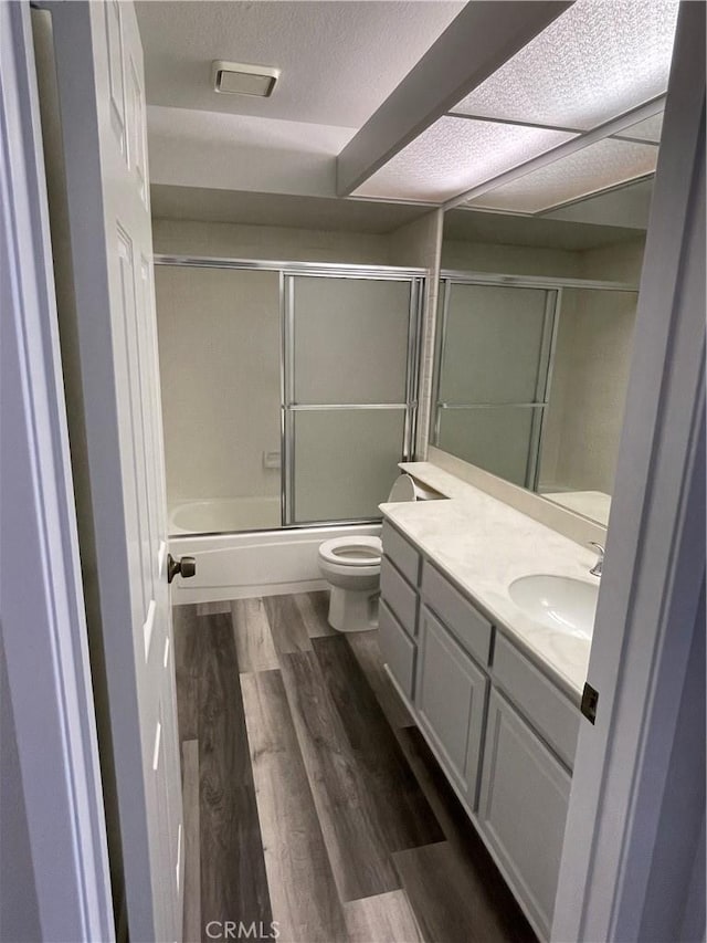 33741 Edgewater Dr Unit 164, Dana Point, CA 92629 - full bath featuring toilet, wood finished floors, vanity, combined bath / shower with glass door, and a textured ceiling