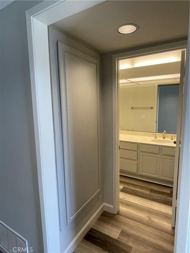 bathroom featuring vanity, baseboards, and wood finished floors