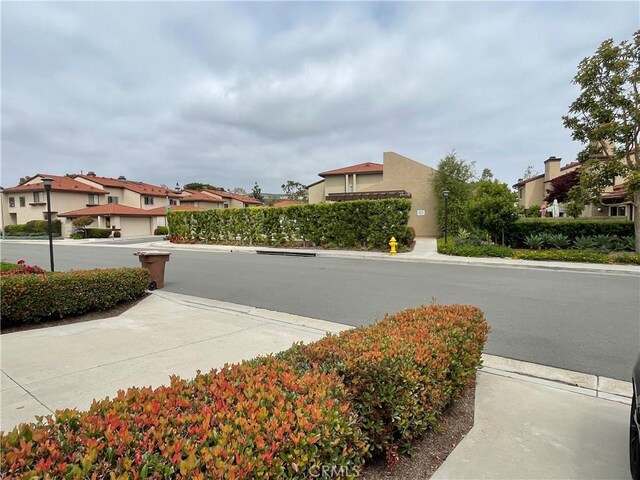 view of street featuring a residential view, sidewalks, and street lights